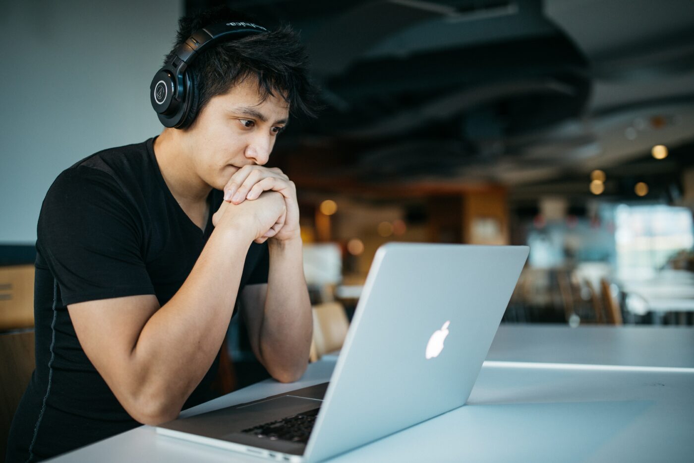 wes-hicks-4-EeTnaC1S4-unsplash.jpg A man with headphones on staring at his laptop screen